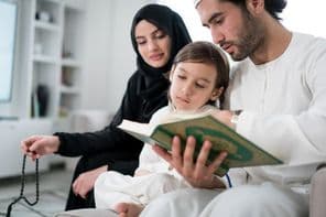 Young parents reading the Koran to their son during Ramadan.