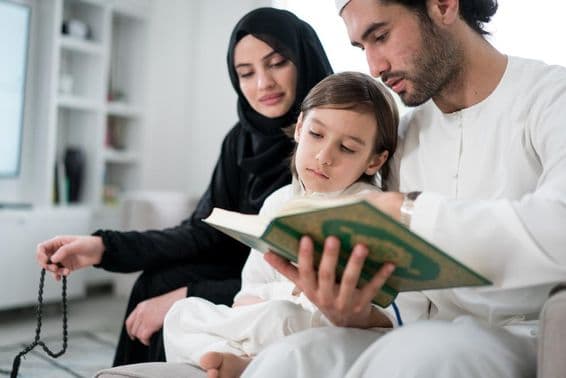 Young parents reading the Koran to their son during Ramadan.