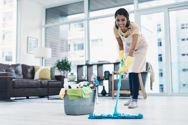 Happy woman cleaning with bucket and mop.