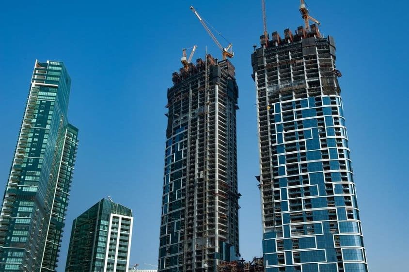 Modern skyscraper apartment complex under construction on the seashore.
