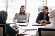 businesswoman talking with Arab partners.