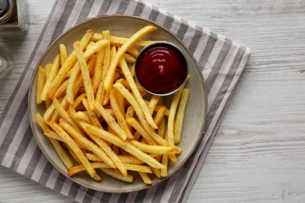 Homemade fries and ketchup on a plate.