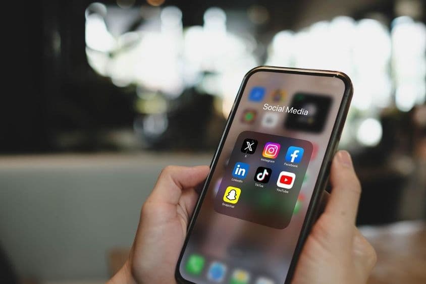 iPhone 15 Pro screen with social media app icons.