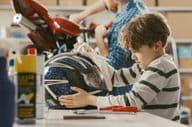 Boy cleaning a helmet.