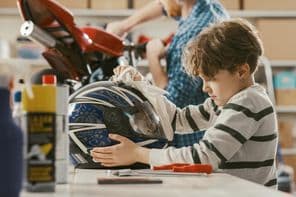 Boy cleaning a helmet.
