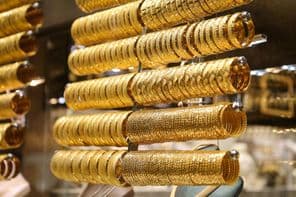 Gold bracelets in a jewelry store display.