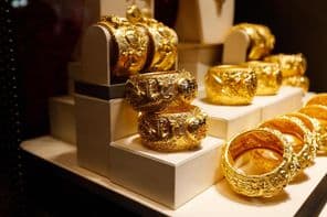 Gold jewelry displayed in a store window.