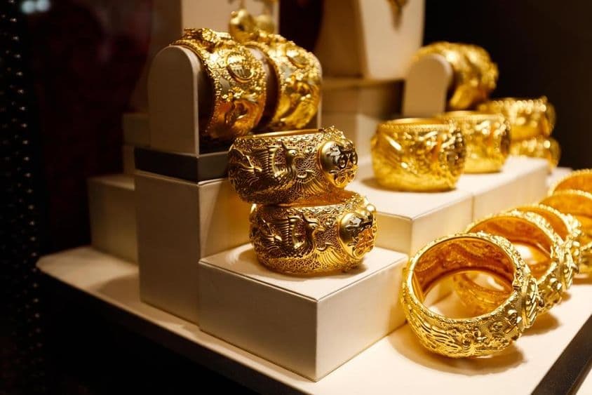 Gold jewelry displayed in a store window.