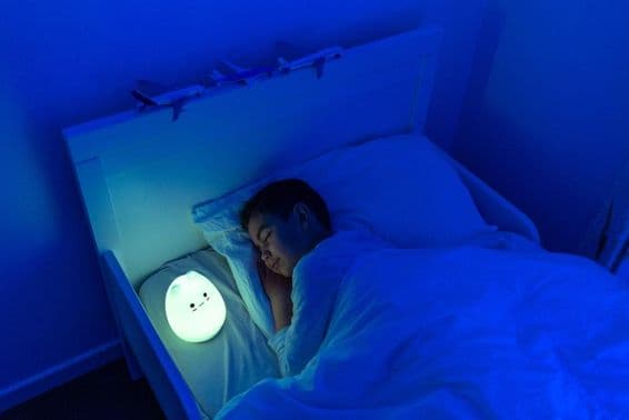 boy sleeping with LED bedside lamp.