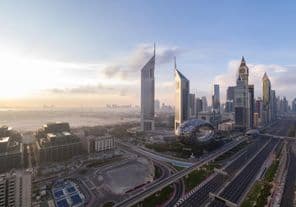 Sheikh Zayed Road with Dubai skyline at sunrise.