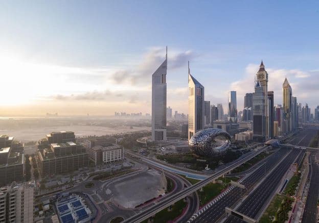 Sheikh Zayed Road with Dubai skyline at sunrise.