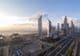 Sheikh Zayed Road with Dubai skyline at sunrise.