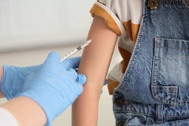 A young girl receiving a vaccine.