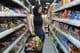 A young Arab woman looks at snacks in a supermarket.