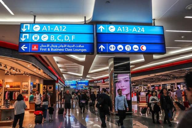 Passengers walking to departure gates at Dubai International Airport.