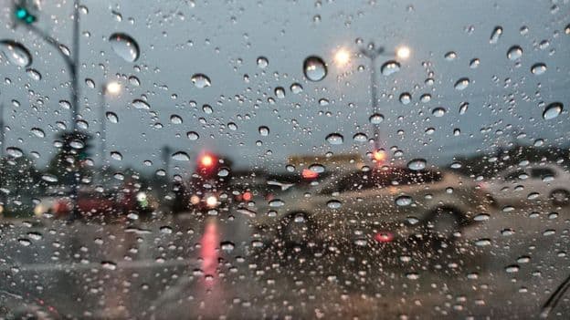 Raindrops on a blurred background seen from a car window