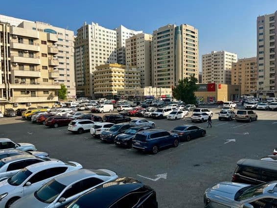 Large parking lot filled with cars in Sharjah, United Arab Emirates.