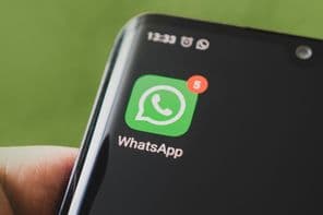 The WhatsApp icon on a black smartphone screen.