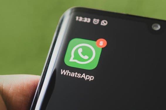 The WhatsApp icon on a black smartphone screen.
