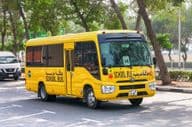 Toyota Coaster school bus on a street in Dubai.
