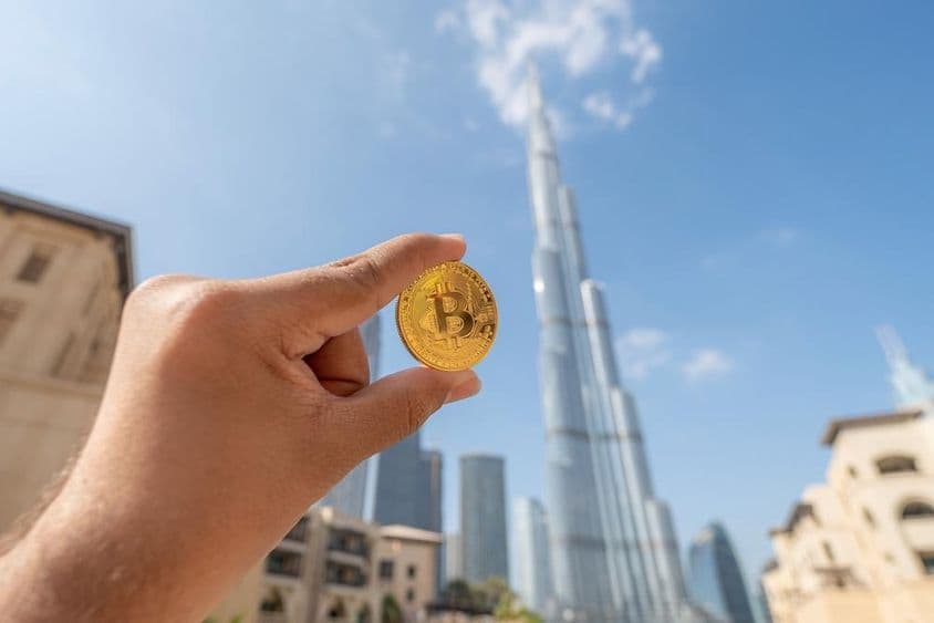 Golden Bitcoin with Dubai skyline in the background