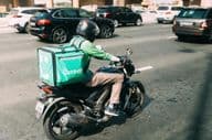 Courier delivering food on a scooter.