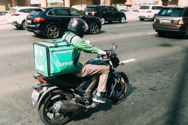 Courier delivering food on a scooter.