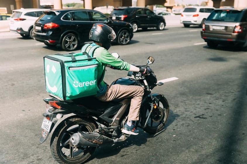 Courier delivering food on a scooter.