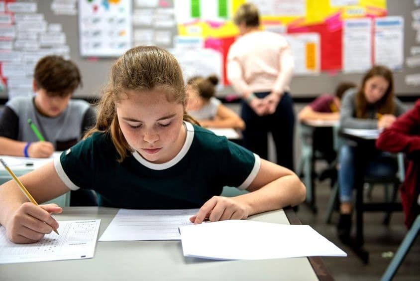 Students taking exams in a classroom.