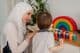 A Muslim teacher and a preschool child playing with colorful toys