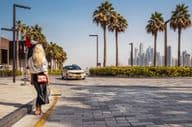 Woman standing on the street, waiting for a taxi.