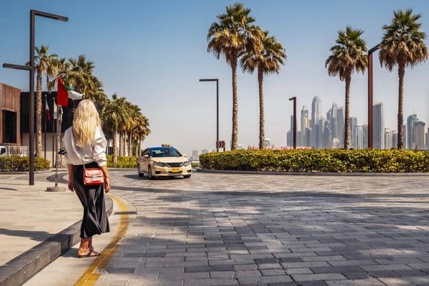 Woman standing on the street, waiting for a taxi.