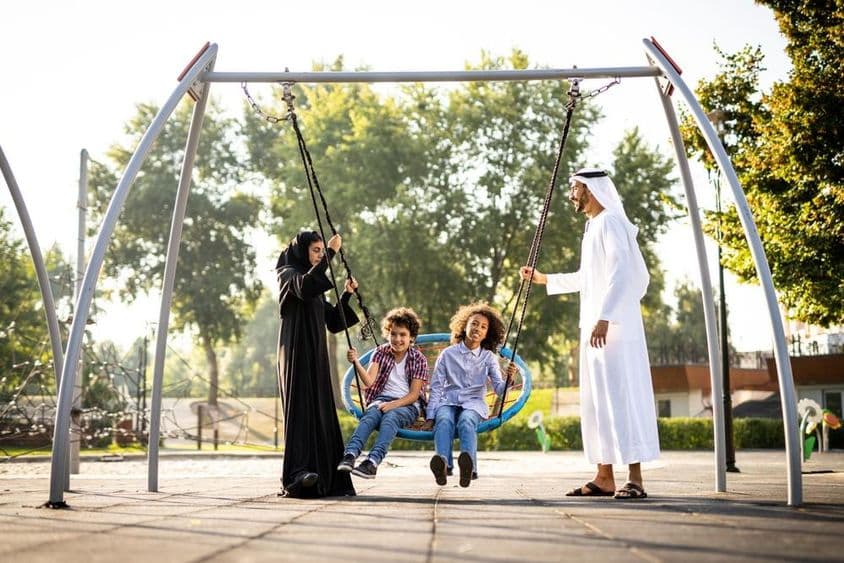 a family playing at the playground in Dubai