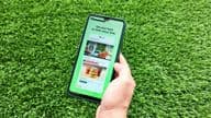 A woman holding a mobile phone while opening the Careem app.
