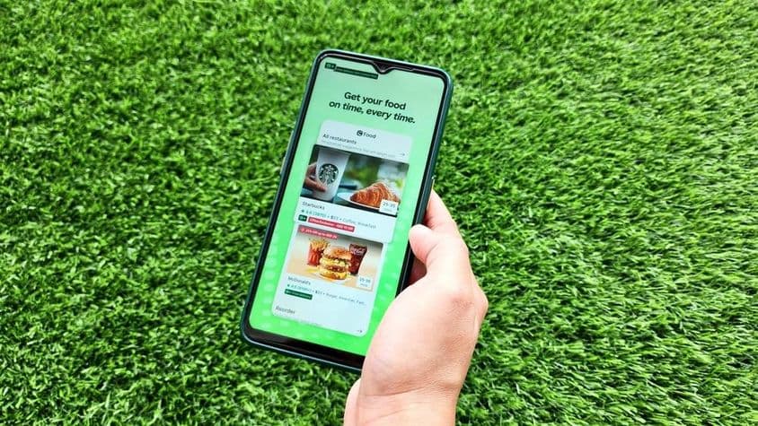 A woman holding a mobile phone while opening the Careem app.