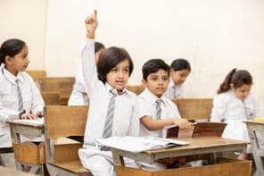 Happy Indian school child raising hand