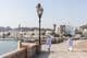 Men in traditional Omani attire along Muscat waterfront.