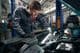 The worker performs a comprehensive technical inspection of the car