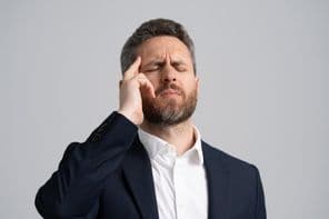 Businessman in a suit having a headache.