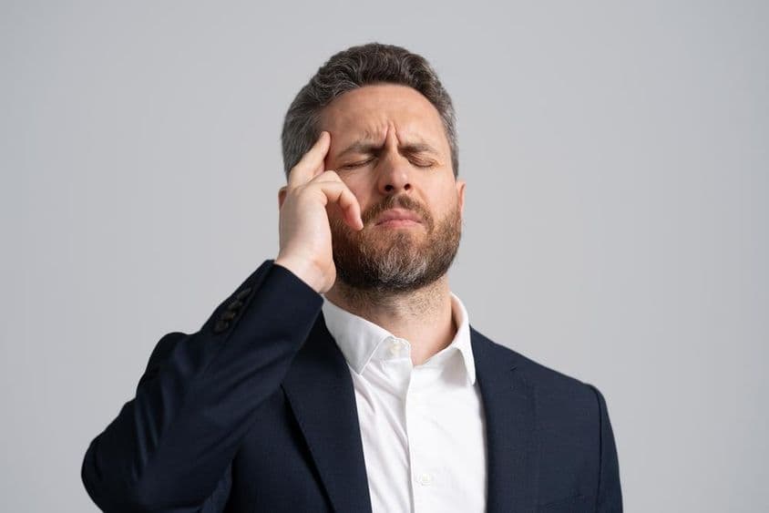 Businessman in a suit having a headache.