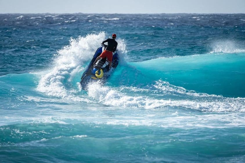 Jetski hits the water above a breaking wave